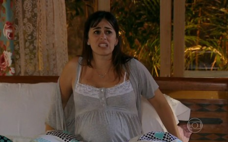 A atriz Daniela Escobar usa barriga falsa para simular gestação e exibe expressão de dor como Nathália em Flor do Caribe