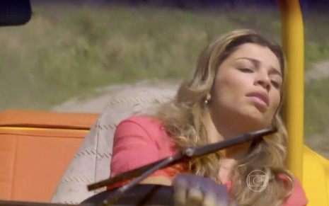Grazi Massafera em cena de Flor do Caribe: caracterizada como Ester, personagem está desmaiada enquanto dirige carro