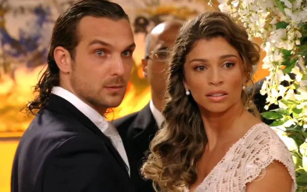 Os atores Igor Rickli e Grazi Massafera, vestidos como noivos, em cena como Alberto e Ester na novela Flor do Caribe