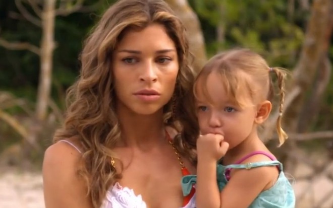 A atriz Grazi Massafera, com a atriz mirim Serena e Vitoria Lovatel, no coloco, com expressão de choque, em cena como Ester em Flor do Caribe