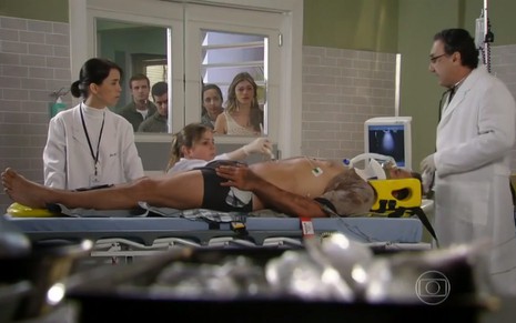 O ator Henri Castelli, em uma maca no hospital, em cena como Cassiano em Flor do Caribe