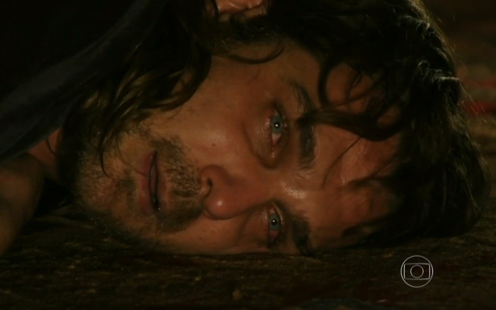 O ator Igor Rickli, com expressão de louco, deitado no chão com lágrimas nos olhos, em cena como Alberto em Flor do Caribe