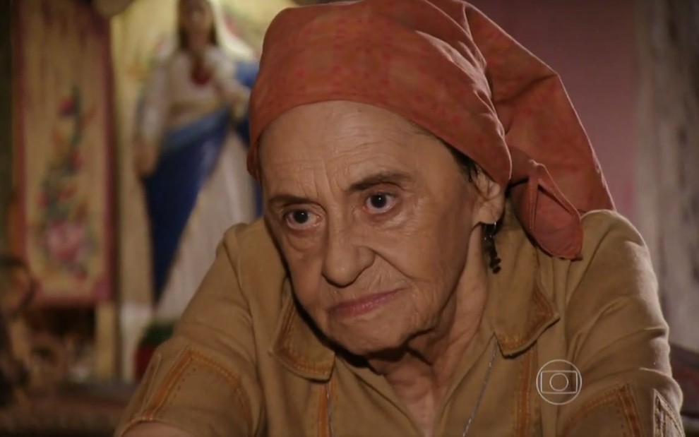 A atriz Laura Cardoso, sentada, com lenço na cabeça, em cena como Veridiana, em Flor do Caribe
