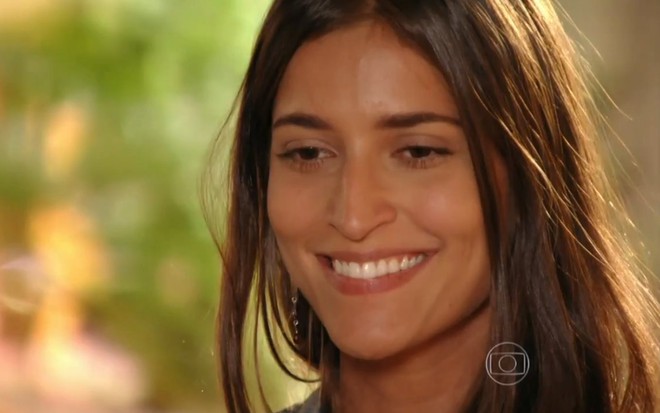 A atriz Maria Joana, com um largo sorriso no rosto, em cena como Carol, em Flor do Caribe