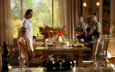 Cena com os atores Grazi Massafera, Igor Rickli, Henri Castelli e Vitor Figueiredo tomando café em uma mesa, na novela Flor do Caribe