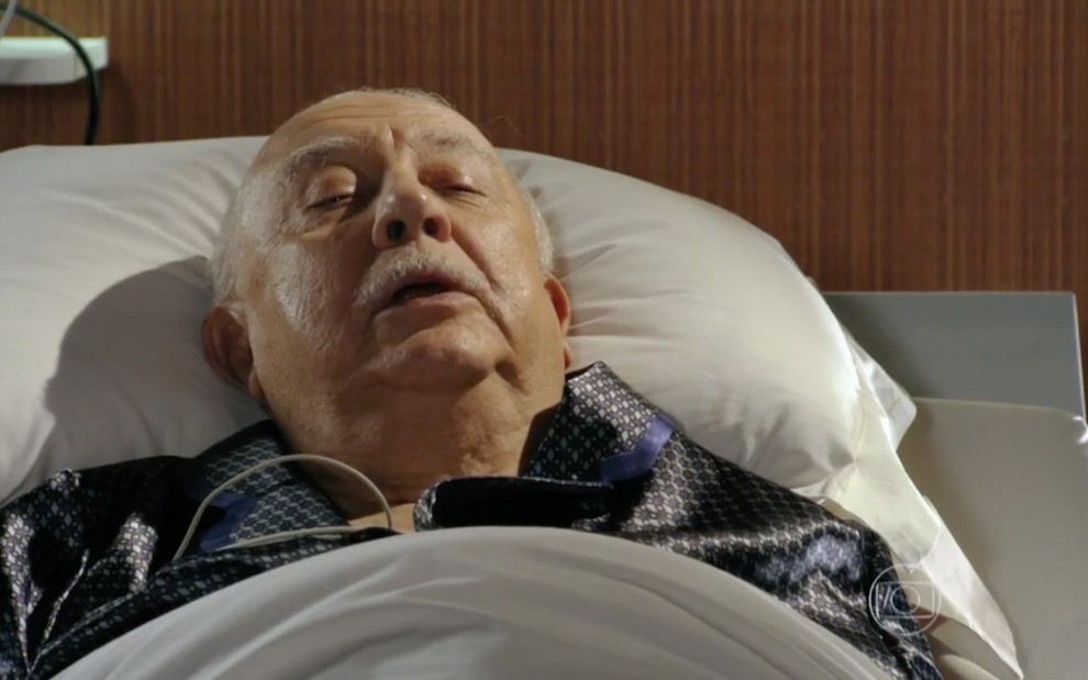 O ator Sérgio Mamberti caracterizado como Dionísio em cima de uma cama de hospital em cena de Flor do Caribe