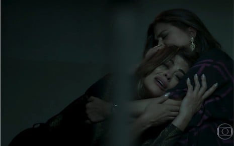 A personagem Bibi, interpretada por Juliana Paes, chora no colo de sua mãe Aurora (Elizangela) na prisão após ser presa por envolvimento com o tráfico de dro