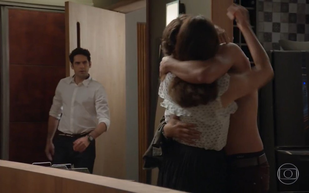 Beto (João Baldasserini) abre a porta e se choca ao flagrar Penélope (Carolina Ferraz) aos beijos com Henrique (Nando Rodrigues)