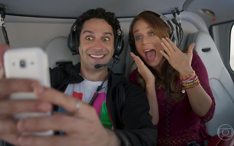 Os atores João Balsasserini e Mariana Ximenes, em um helicóptero, em cena como Beto e Tancinha em Haja Coração