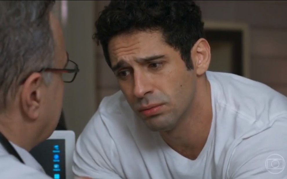 O ator João Baldasserini, com expressão de tristeza, em cena como Beto na novela Haja Coração