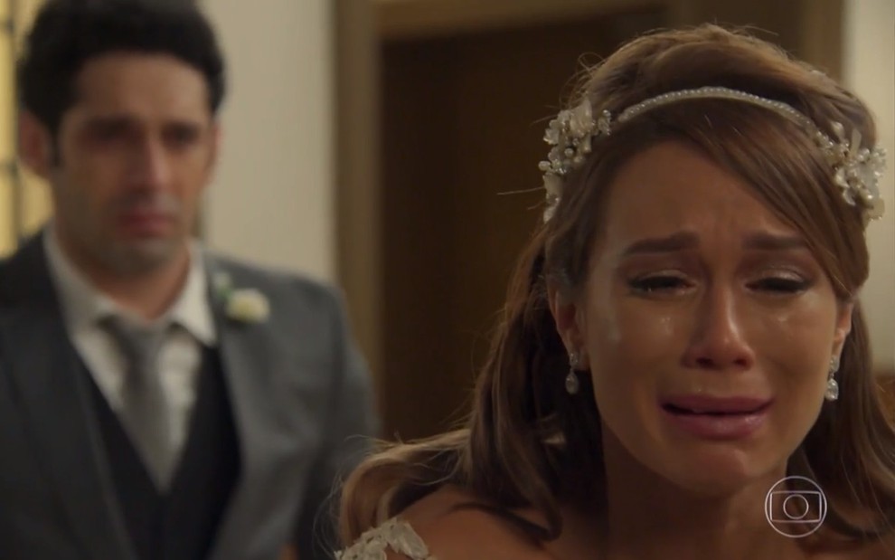 A atriz Mariana Ximenes chora vestida de noiva em cena como Tancinha em Haja Coração, reprise da Globo