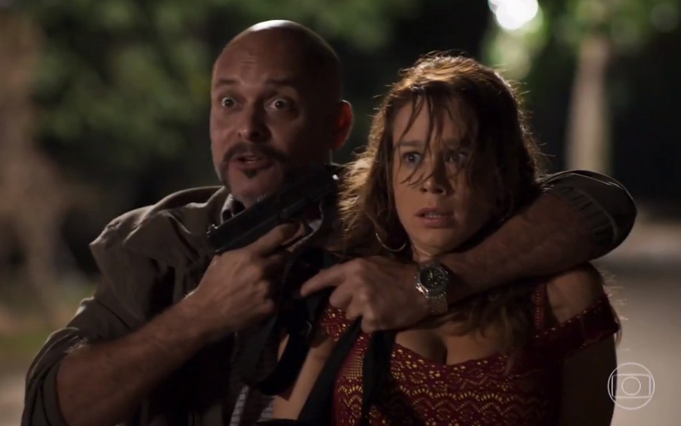 A atriz Mariana Ximenes, em cena de sequestro, com uma arma apontada na cabeça, em cena como Tancinha em Haja Coração