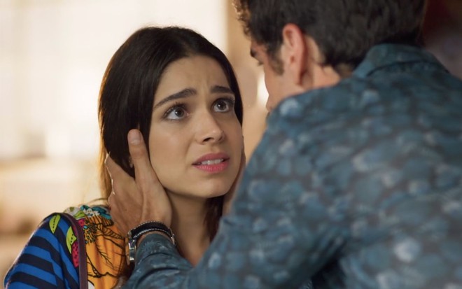 Cena da novela Haja Coração: Shirlei (Sabrina Petraglia, à esquerda) olha assustada, enquanto Felipe (Marcos Pitombo, de costas) segura o rosto dela
