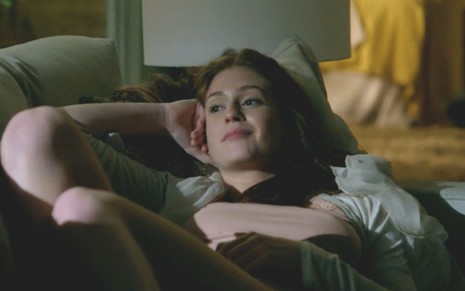 Marina Ruy Barbosa em cena de Império: caracterizada como Maria Isis, atriz está deitada em sofá e olha para o horizonte