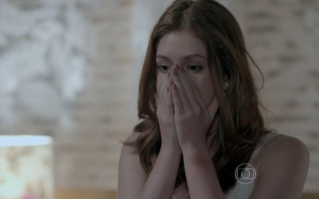 Marina Ruy Barbosa grava com as mãos no rosto chocada com algo que vê como Maria Isis de Império, novela das nove da Globo