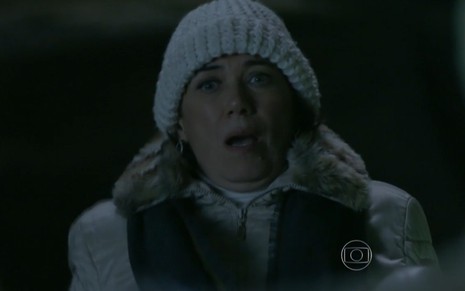 Lilia Cabral grava de noite com gorro branco e colete de pelos com expressão assustada como Maria Marta