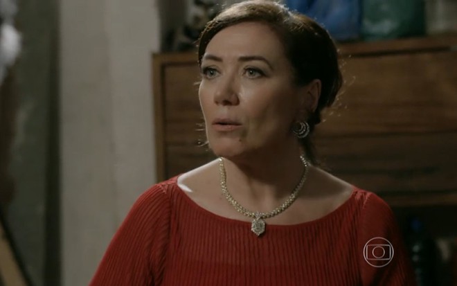 Lilia Cabral grava de vestido vermelho e joias sofisticadas com cara de enjoo como Maria Marta de Império