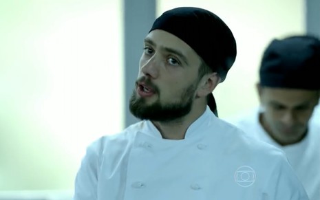 Rafael Cardoso grava vestindo branco e touca de cozinheiro como Vicente na novela Império