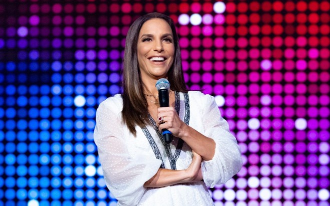 Ivete Sangalo com roupa branca e segurando microfone no Tamanho Família, em 2019