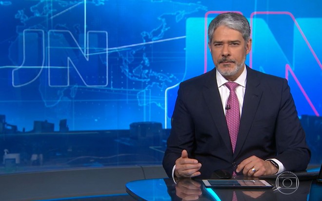 William Bonner no Jornal Nacional de terno preto e gravata rosa