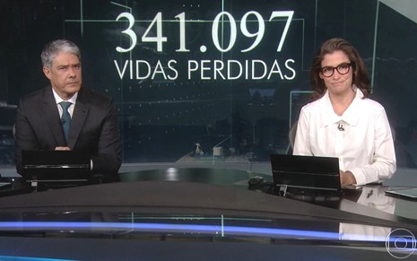 William Bonner e Renata Vasconcellos no estúdio Jornal Nacional, com o número de mortes pela Covid-19 ao fundo