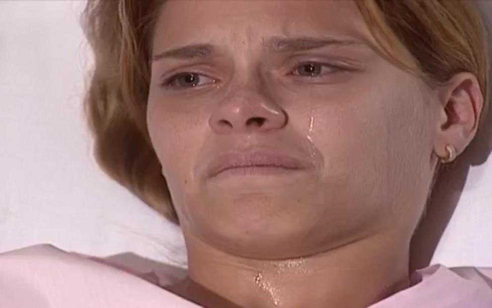 A atriz Carolina Dieckmann exibe expressão de sofrimento, chorando, em cena como Camila em Laços de Família