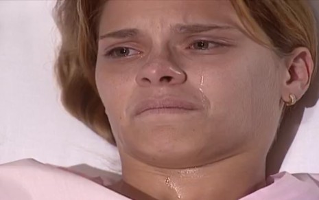 A atriz Carolina Dieckmann exibe expressão de sofrimento, chorando, em cena como Camila em Laços de Família
