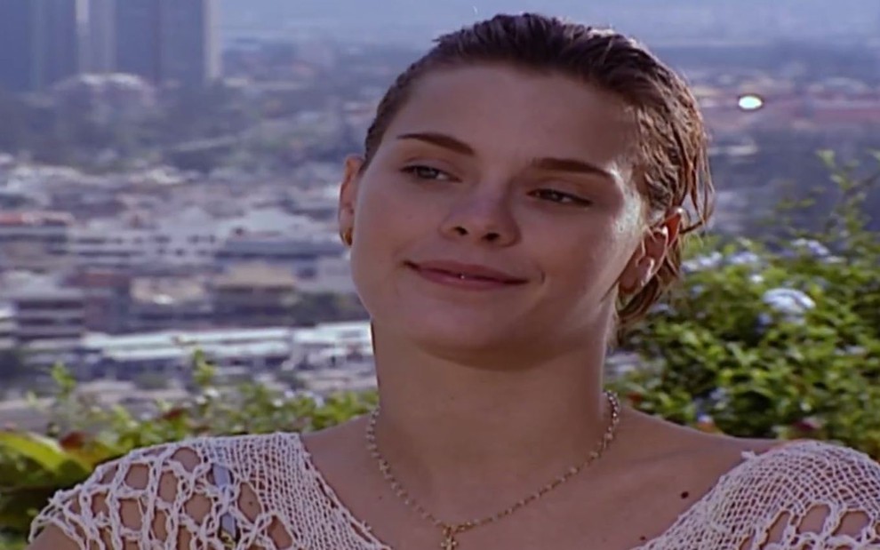 A atriz Carolina Dieckmann, com um levo sorriso no rosto, em cena como Camila em Laços de Família