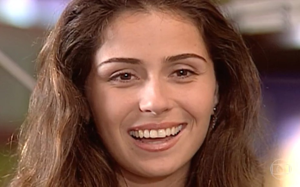 A atriz Giovanna Antonelli, com um enorme sorriso no rosto, em cena como Capitu em Laços de Família