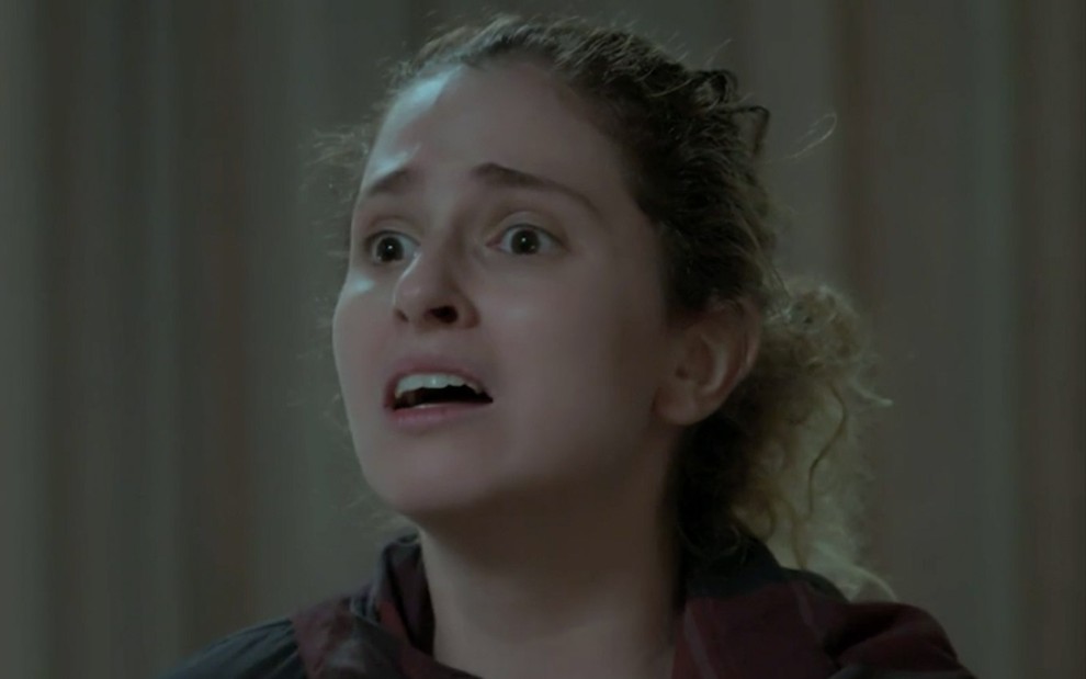 Carol Duarte caracterizada como Ivana em A Força do Querer: personagem está de cabelo preso e tem olhar desesperado para alguém fora do quadro