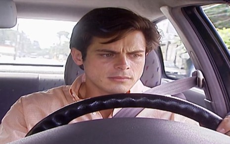 O ator Luigi Baricelli, sentado no carro, com expressão de tristeza, em cena como Fred e Camila em Laços de Família