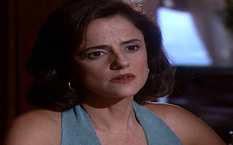A atriz Marieta Severo, com expressão de desânimo, em cena como Alma em Laços de Família
