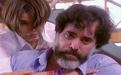 Tony Ramos e Júlia Feldens em cena de Laços de Família: ator olha com raiva para alguém fora do quadro e é segurado por atriz