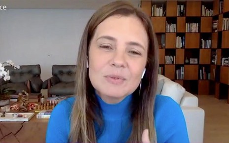 Adriana Esteves em entrevista para o Mais Você desta terça (16): sentada, atriz está em casa e usa cacharrel azul escura, cabelo solto e fones de ouvido