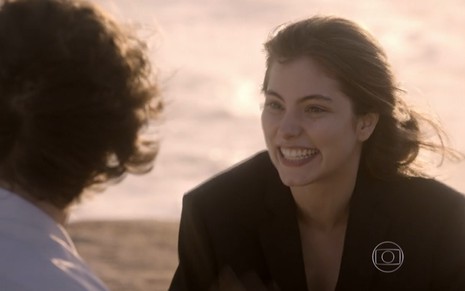 Bruna Hamú grava na praia com cabelo esvoaçante e sorriso estampado no rosto como Bianca de Malhação Sonhos