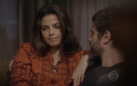 Emanuelle Araújo grava de camisa laranja com estampa e expressão de insatisfação ao lado de Eriberto Leão como Dandara e Gael
