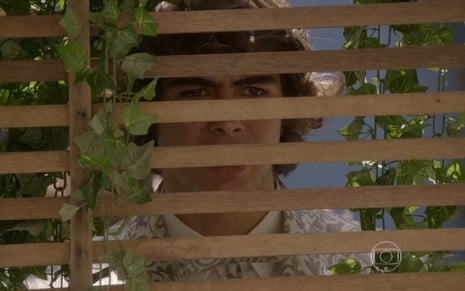 Rafael Vitti grava atrás de uma grade com olhar de surpresa como Pedro em Malhação Sonhos
