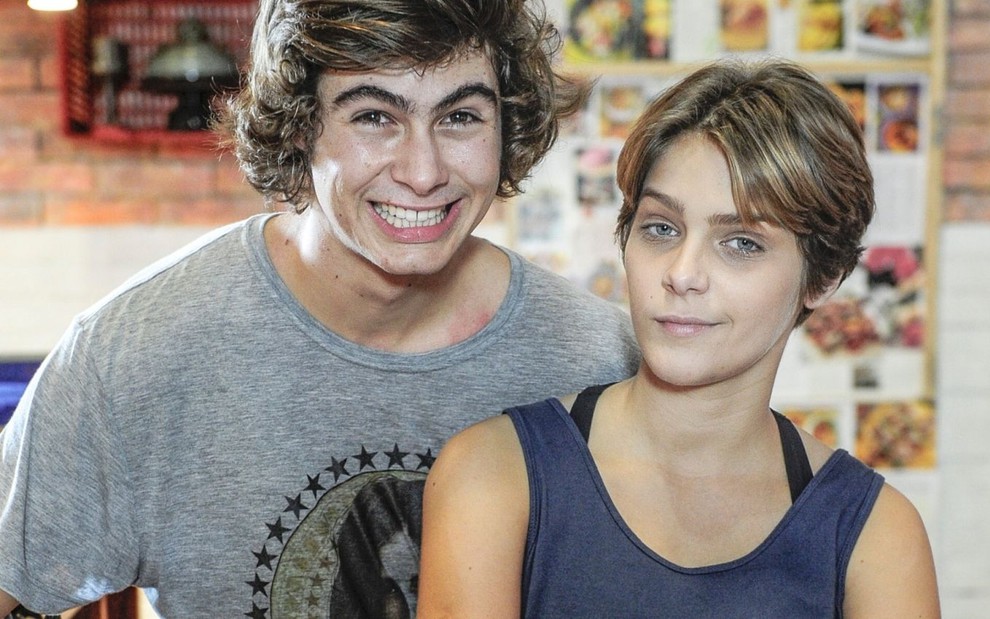 Rafael Vitti sorri forçadamente e Isabella Santoni tem expressão blasé em foto posada de Malhação