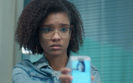A personagem Ellen (Heslaine Vieira) segura um celular em cena da novela Malhação - Viva a Diferença, da Globo