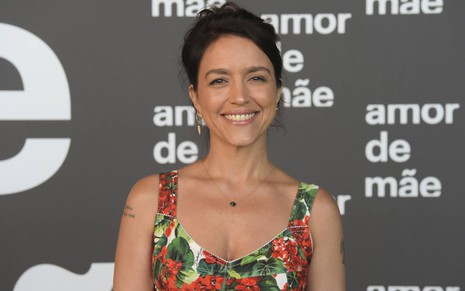 A autora Manuela Dias, posando para fotos, sorrindo, com um vestido florido