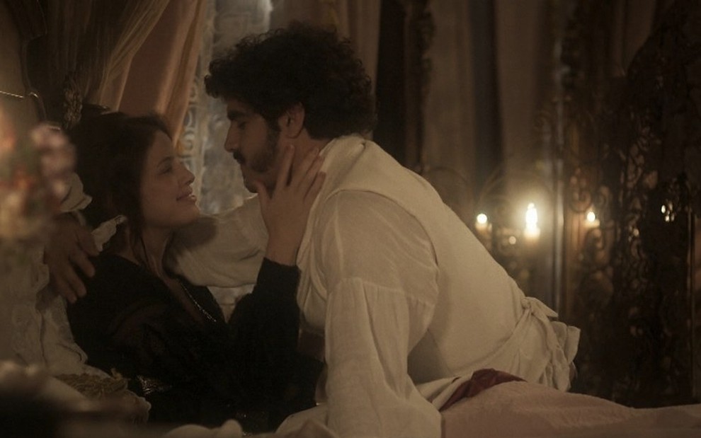 Os atores Agatha Moreira e Caio Castro como Domitila e Pedro se abraçam em cima de uma cama em cena de Novo Mundo