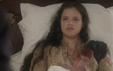 A atriz Agatha Moreira com expressão de desprezo e roupas sujas de sangue na altura do ombro como a Domitila em cena de Novo Mundo