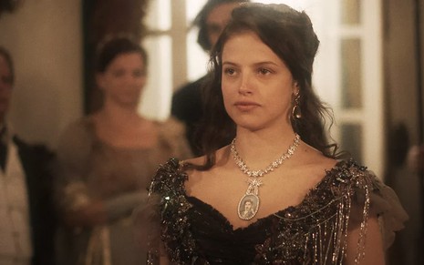 A atriz Agatha Moreira caracterizada como Domitila usa um colar com a imagem de Caio Castro, o Pedro, em cena de Novo Mundo