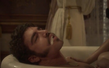 O ator Caio Castro dentro de uma banheira com espuma na boca durante ataque epiléptico de Pedro em Novo Mundo
