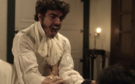 O ator Caio Castro, o Pedro, com expressão de fúria, está em cima de Romulo Estrela, o Chalaça, em cena de Novo Mundo