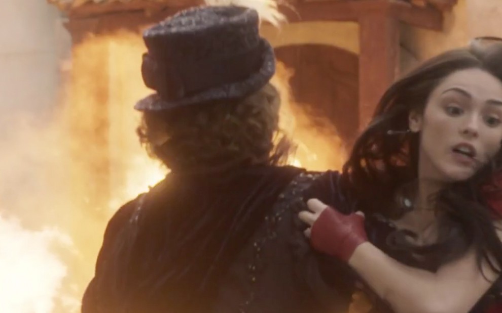 A atriz Leticia Colin, a Leopoldina de costas, é empurrada por Isabelle Drummond, a Anna, para longe de uma explosão em cena de Novo Mundo
