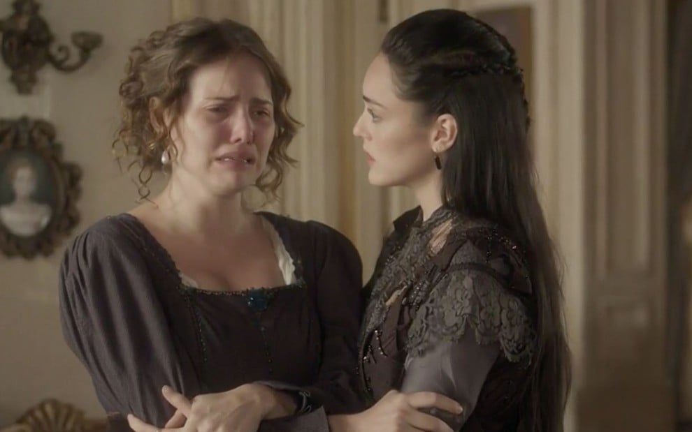 A atriz Leticia Colin, a Leopoldina, chora enquanto é abraçada por Isabelle Drummond, a Anna, em cena de Novo Mundo