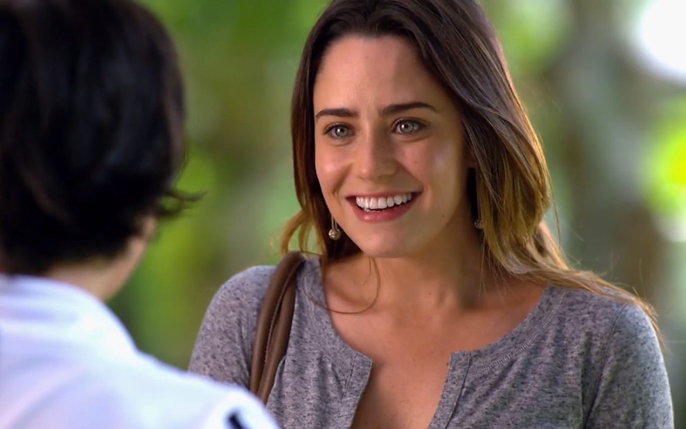 A atriz Fernanda Vasconcellos, com um grande sorriso no rosto, em cena como Ana em A Vida da Gente