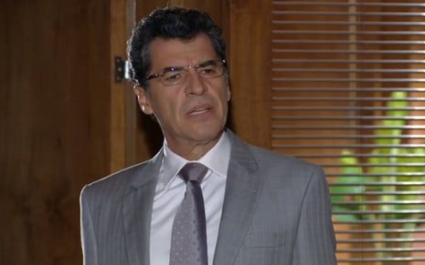 O ator Paulo Betti, de terno e gravata, com expressão de dúvida em cena como Jonas em A Vida da Gente