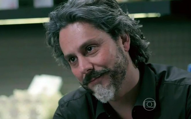 o ator Alexandre Nero, com um sorriso de satisfatção, em cena como José Alfredo em Império